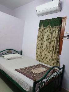 a room with a bed with a curtain on it at Full Moon House Tiruvannamalai in Tiruvannāmalai