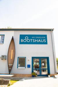 a bookshop with a blue sign on the side of a building at Boootshaus - Am Spreeufer in Beeskow