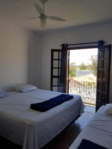 a bedroom with two beds and a door to a balcony at Hostel BoituVillage in Boituva