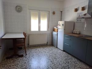a kitchen with a table and a refrigerator at CASA ANTONIO Y GABI Ruta de los dinosaurios in Igea