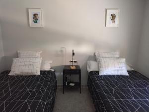 a bedroom with two beds and a side table at CASA ANTONIO Y GABI Ruta de los dinosaurios in Igea