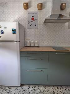 uma cozinha com um frigorífico branco e armários azuis em CASA ANTONIO Y GABI Ruta de los dinosaurios em Igea