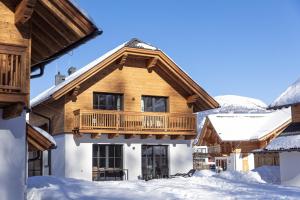 マリアプファルにあるAlpiNest Feriendorf Lungauのログホーム 雪の中のバルコニー付