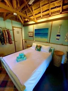 a bedroom with a large white bed with two pillows at DJs Beach Resort in Union