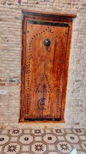 uma porta de madeira numa parede de tijolos com em Appartement Berbère em Tozeur