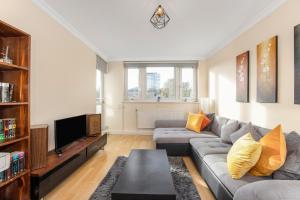 uma sala de estar com um sofá e uma televisão em Easy living near Angel and City University em Londres