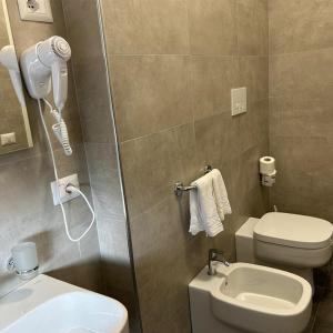 uma casa de banho com um chuveiro, um WC e um telefone em Villa Angeli em Roma