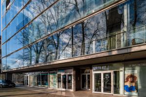 un edificio con un reflejo de árboles en las ventanas en Romeo Family Kaarli Apartment, en Tallin