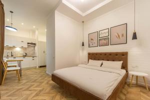 um quarto com uma cama grande e uma cozinha em Idea Design Apart-Hotel Chykalenka em Kiev