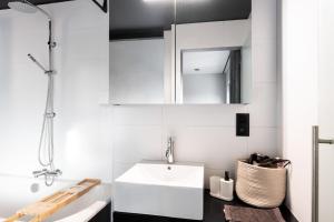 Baño blanco con lavabo y espejo en Spacious & Chic House in Center, en Cortrique