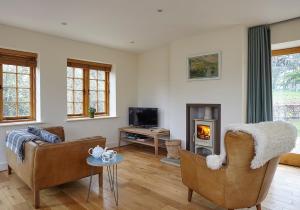 a living room with two chairs and a fireplace at The Squeak at Moor Farm in Godshill