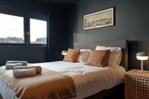 a bedroom with a large bed with two windows at Spacious & Chic House in Center in Kortrijk