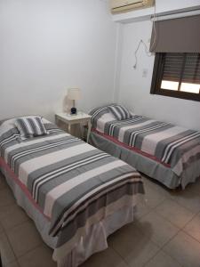 2 Betten nebeneinander in einem Zimmer in der Unterkunft Céntrico departamento en Corrientes in Corrientes