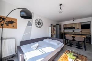 ein Wohnzimmer mit einem Bett und eine Küche in der Unterkunft F2 Cozy Pour 4 Proche Disneyland - Fairytale Factory in Villeneuve-Saint-Denis