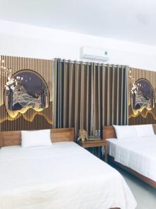 um quarto com 2 camas e uma parede com espelhos em TAMCOC VUTHANH FRIENDLY Hotel em Ninh Binh