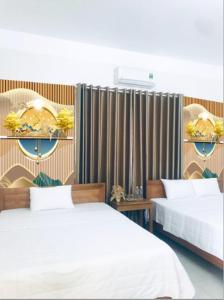 a bedroom with two beds and a curtain at TAMCOC VUTHANH FRIENDLY Hotel in Ninh Binh