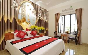 a bedroom with a large bed with red pillows at TAMCOC VUTHANH FRIENDLY Hotel in Ninh Binh