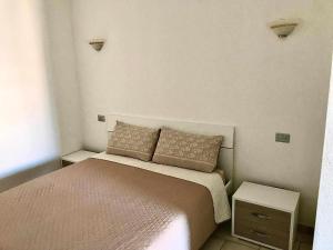 a small bedroom with a bed and two night stands at Villa Bianca BB e Apartments in Àrbatax