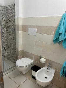 a bathroom with a toilet and a sink at Villa Bianca BB e Apartments in Àrbatax