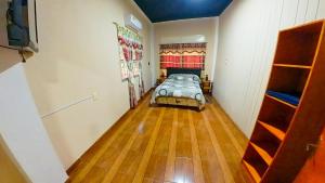 um quarto com uma cama e piso em madeira em Lumay em Puerto Iguazú