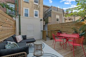 a patio with a couch and tables and chairs at Passyunk Square Spacious 1 BR Oasis- Huge Deck in Philadelphia