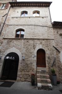 een bakstenen gebouw met een deur en een trap voor de deur bij Residenza Sant'Agnese in Assisi