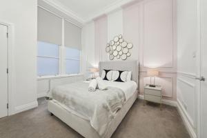 a white bedroom with a large bed and a window at (G5) Grand 1 bed Blythswood Apartment in Glasgow