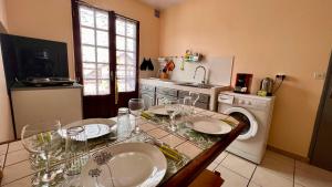 a kitchen with a table and a washing machine at Rev' Horizon in Le Tampon
