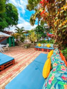 a patio with blue and orange furniture and trees at Pousada Catavento in Pipa