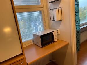 a microwave sitting on a table next to a window at Studiohuoneisto Lohja keskusta in Lohja