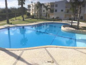 a large blue swimming pool in front of a building at Close to beach Alvor 1 bedroom apartment Villa da Praia AT08 in Alvor
