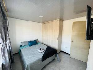 ein Schlafzimmer mit einem Bett mit einem Buch darauf in der Unterkunft Como en casa super equipado in Popayan