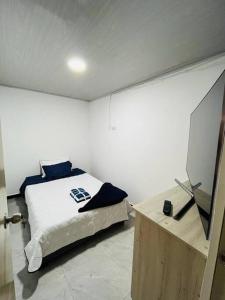 ein Schlafzimmer mit einem Bett und einem TV auf einem Tisch in der Unterkunft Como en casa super equipado in Popayan
