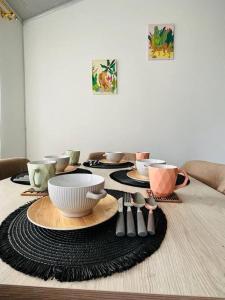 un tavolo con piatti, ciotole e utensili sopra di Como en casa super equipado a Popayan