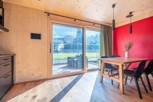 ein Esszimmer mit einem Holztisch und einem großen Fenster in der Unterkunft The Swiss Bijou / Alpine Retreat in Stans