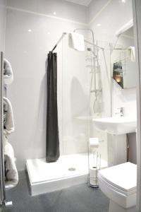 a bathroom with a shower and a toilet and a sink at Lauriston & Lawton Court Hotel in Llandudno