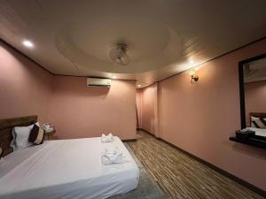 Haad Khuad Resort في شاطئ بوتيل: غرفة بها سرير مع منشفتين