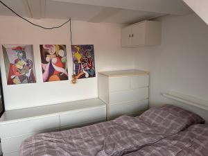 1 dormitorio con 3 cuadros en la pared y 1 cama en Værelse i lejlighed med udsigt og ro, en Aarhus
