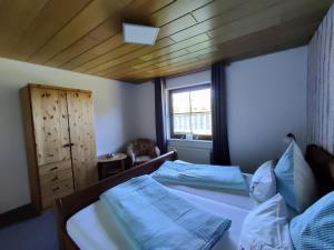 Schlafzimmer mit einem Bett mit blauer Bettwäsche und einem Fenster in der Unterkunft Komfort Ferienwohnung in Herscheid