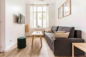 a living room with a couch and a table at Appartement RDC Mairie de Marcq in Marcq-en-Baroeul