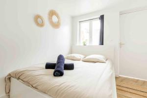 a white bedroom with a large bed with two pillows at Appartement RDC Mairie de Marcq in Marcq-en-Baroeul