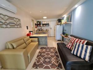 uma sala de estar com um sofá e um frigorífico em Tabatinga Residence Flat Family Kids 04 em Conde