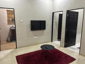 a room with a table and a tv on a wall at Exquisite 2 bedroom apartment in Abuja