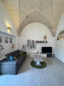 ein Wohnzimmer mit einem Sofa und einem Tisch in der Unterkunft Casa Alla Fasanese in Fasano