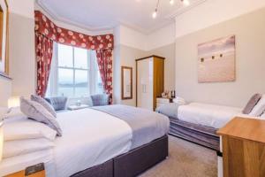 a bedroom with two beds and a window at Lauriston & Lawton Court Hotel in Llandudno