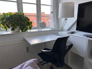 Cette chambre dispose d'un bureau et d'une chaise. dans l'établissement Værelse i lejlighed med udsigt og ro, à Aarhus