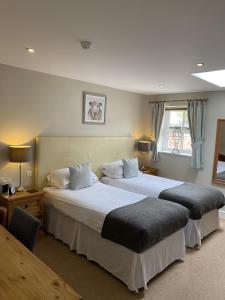 a bedroom with two beds and a window at New Farm Cheshire B&B in Winsford