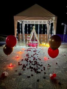 una mesa con globos rojos y una pila de confeti en Buen Vivir Restrepo a 30 minutos Lago Calima en Restrepo