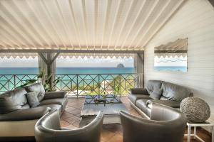 uma sala de estar com sofás e vista para o oceano em Cœur de Diams em Le Diamant