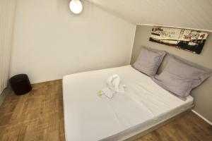 a small bedroom with a bed with white sheets and pillows at Cœur de Diams in Le Diamant